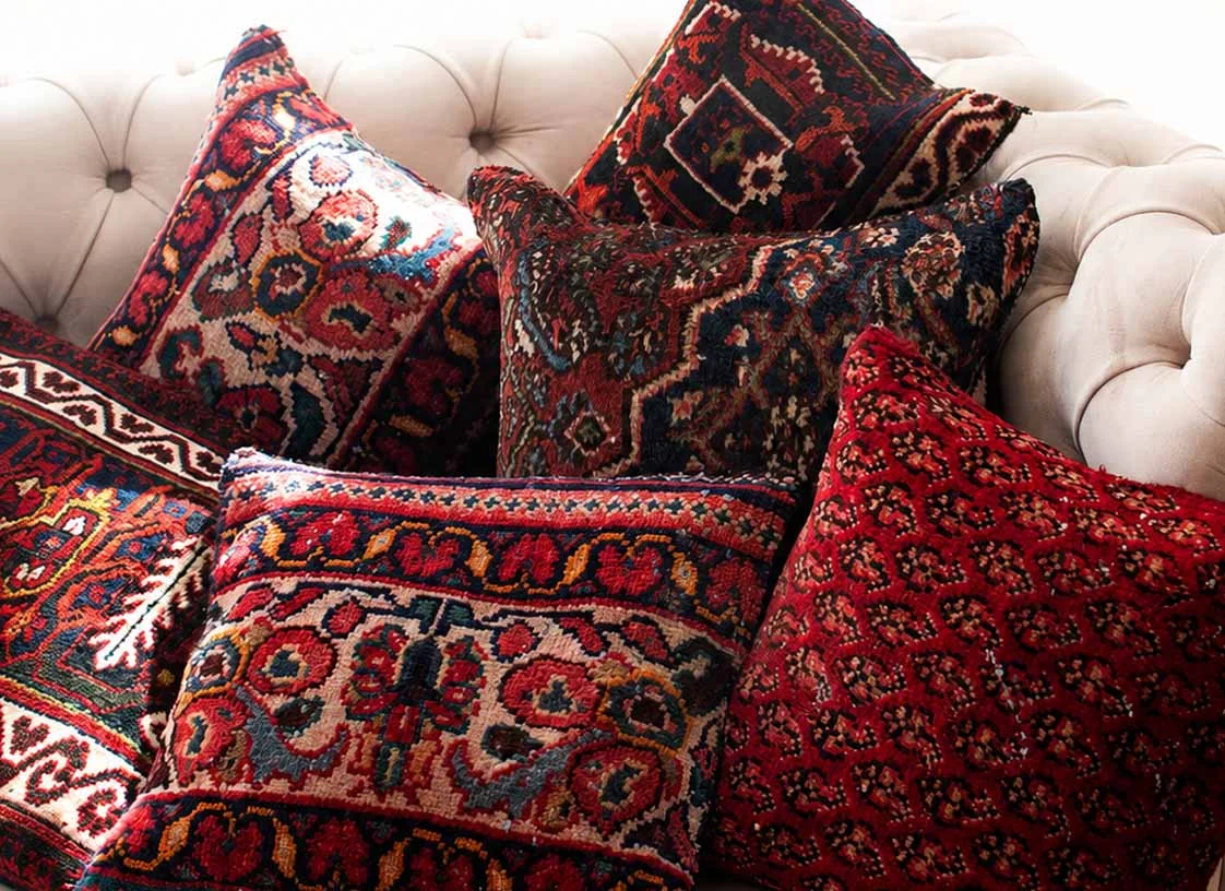 Best colors and patterns of authentic handwoven Persian rug cushions styled on a neutral sofa for a warm and luxurious living room.