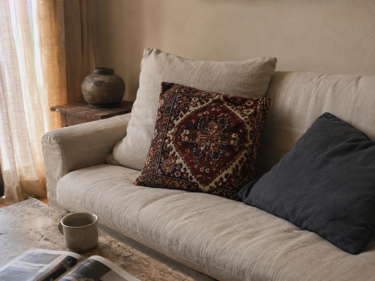 Persian rug cushion styled with neutral linen cushions on a modern minimalist cream sofa
